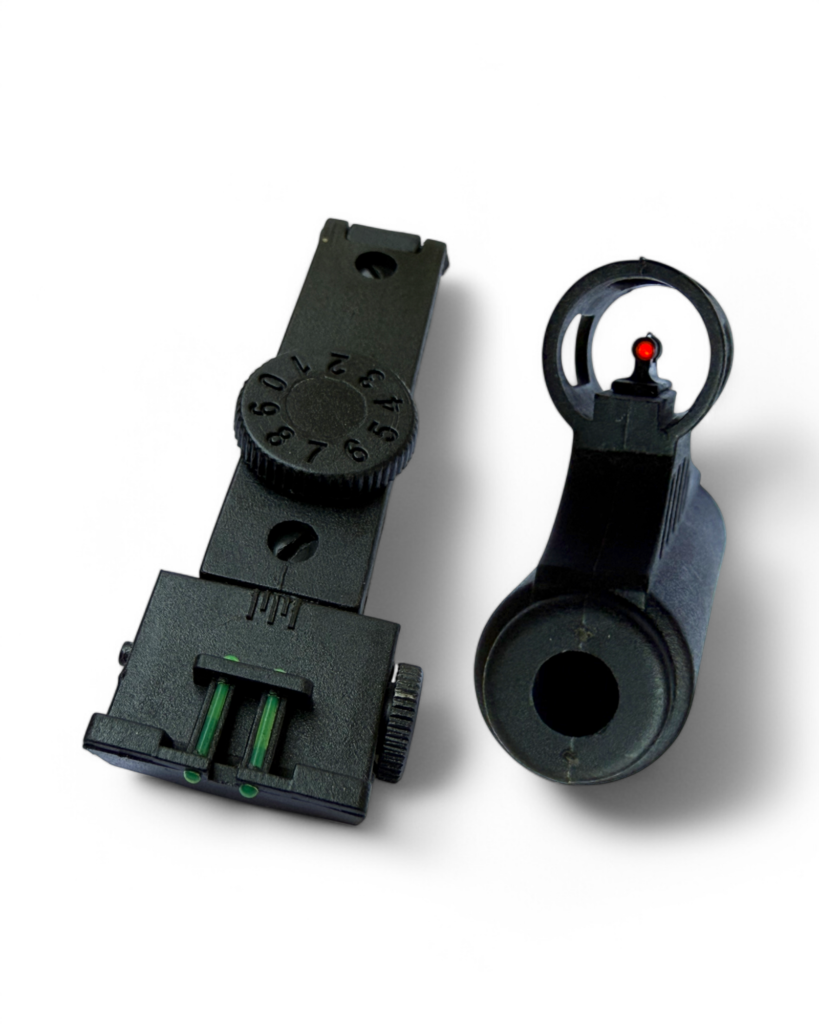 Black tactical rifle sight mount with adjustable dial and a separate circular red-dot sight ring with a small red dot.