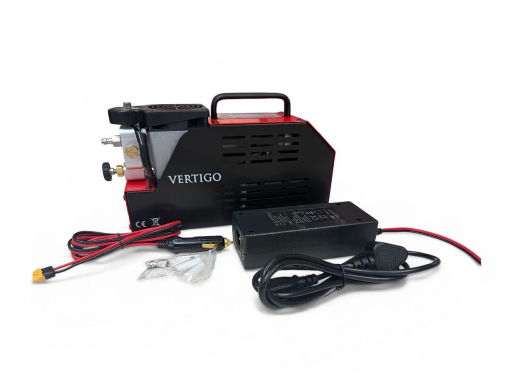 Compact black and red device labeled 'VERTIGO' with a handle and power adapter on a white background.