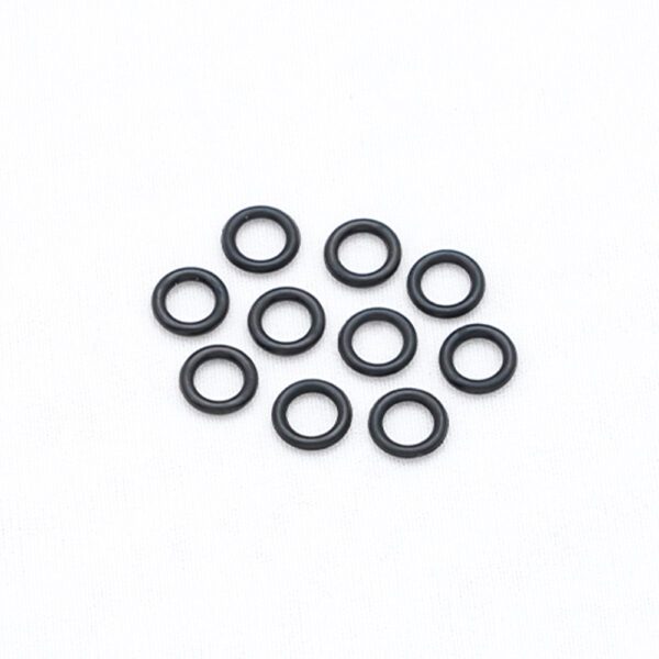 Nine small black O-rings arranged in a loose cluster on a white background