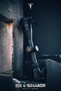 Close-up of a rifle scope mounted on a rail, with a white logo above and product text below reading 'EOX 4-16X44IOR Rifle Scope'
