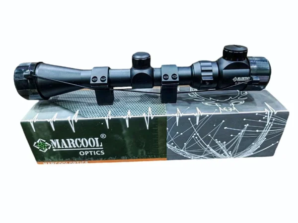 Rifle scope with two mounting rings placed on a MARCOOL OPTICS box, ready for mounting