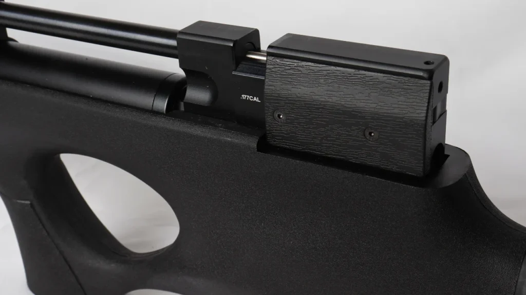 Close-up of a black air rifle showing the receiver mounted on a textured stock, with a small ".177 CAL" marking visible on the breech area.